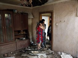 Una familia llora al ver los destrozos de su casa tras la explosión de una bomba durante enfrentamientos en ucrania. EFE /