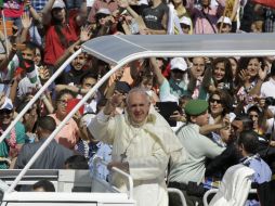 El Papa llega en un automóvil descubierto, rodeado de una discreta seguridad, lo que permite que la gente se acercara al vehículo. AFP /