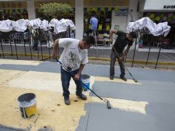 Trabajadores colocan tarimas sobre la calle Zaragoza, donde se ubicarán los locatarios del Mercado Corona.  /