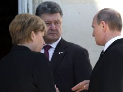 La canciller alemana, Angela Merkel; el presidente ruso, Vladimir Putin (d) y el presidente ucraniano electo, Petro Poroshenko. AP /
