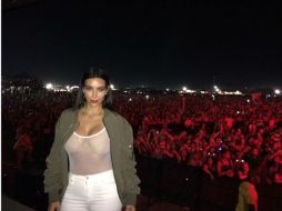 Con miles de fans de fondo, Kim aparece portando una blusa transparente muy al estilo de Rihanna. ESPECIAL /