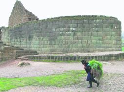 Una joven  mujer inca-cañarí bordeando el templete del Inga Pirca se afana con la pastura para su ganado antes de la lluvia.  /