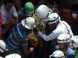 Uno de los mineros sale de la mina apoyado por elementos de la Cruz Verde. EFE /