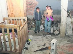 Daños. Una familia observa los destrozos que dejó el fenómeno en su vivienda, en Huixtla. AFP /