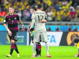 Reconocimiento. Julio Cesar abraza al volante alemán Mezut Özil, mientras David Luiz cae rendido, tras finalizar el juego. EFE /