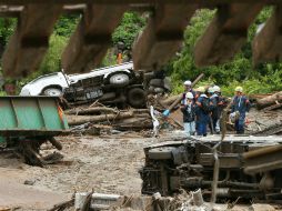 Trabajadores inspeccionan un sitio dañado fuertemente por las tormentas ocasionadas por ''Neoguri''. AFP /