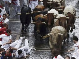 El suelo mojado ha propiciado repetidas caídas de los toros a lo largo de toda la carrera. EFE /