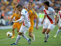 Marco Ruben (c) de Tigres disputa el balón con Carlos Morales (i) de Morelia. EFE /