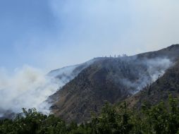 Bomberos tratan de controlar el incendio utilizando aviones para lanzar agua. AP /