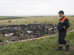 Un miembro de los servicios de rescate ucranianos observa los restos de fuselaje del avión Boeing 777. EFE /