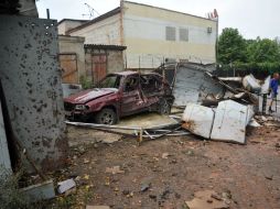 Residentes locales observan parte de su vecindario luego de un tiroteo en la ciudad de Lugansk. AFP /