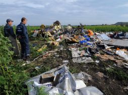 Empleados del Servicio de Estado de Emergencia de Ucrania observan los escombros del avión. AFP /