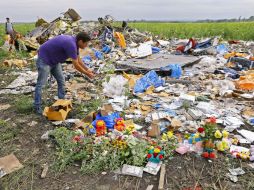 Un periodista inspecciona desde cerca los escombros de la cabina de pilotos del vuelo Boeing 777. EFE /