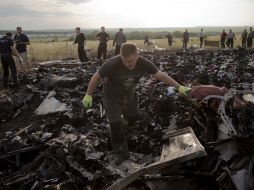 Rescatistas examinan restos del MH17 con 298 pasajeros abordo, caído en el este de Ucrania a causa de un misil. AP /