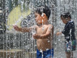 Un niño se refresca en una fuente de Tokio. AFP /
