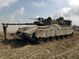 Un soldado de Israel hace ajustes a un tanque posicionado en la frontera entre Israel y Gaza. AFP /