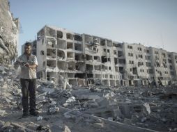 Un palestino inspecciona una billetera en una zona de escombros de un complejo de apartamentos en Gaza. EFE /