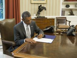 Barack Obama firma la autorización de apoyo para el sistema 'Cúpula de Hierro' desde el Despacho Oval. AP /