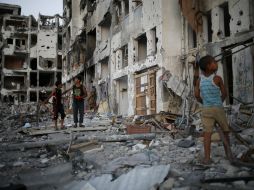 Niños juegan entre los escombros de una torre antes de que venza el alto el fuego en el lugar. EFE /