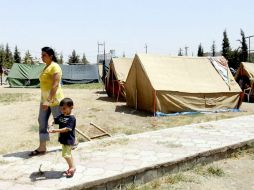 Una mujer y un niño cristianos e iraquíes caminan en un nuevo campo de refugiados forzados a huir de sus hogares. EFE /