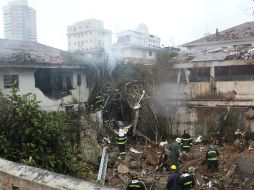 Bomberos trabajan en el sitio del accidente en la ciudad de Santos. AP /