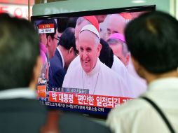 Coreanos ven por televisión la llegada del Papa Francisco a Seúl. AFP /