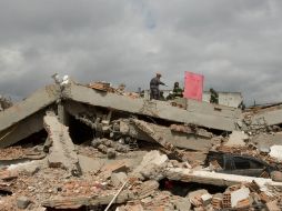 Los rescatistas siguen en el lugar para despejar los cascotes de cemento, e intentar encontrar a más gente. ARCHIVO /