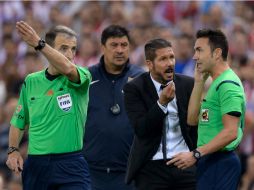 El DT argentino reclama y golpea al cuarto árbitro, Antonio Santos, por lo que fue expulsado del partido. AFP /