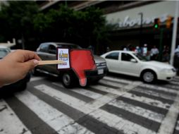 Los participantes utilizan cartoncillos que simulan los iconos de Facebook para calificar la conducta  de automovilistas y peatones.  /