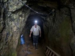Un minero camina dentro del túnel mientras espera que continúen las labores de rescate. AP /