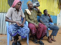 Hombres somalíes escuchan en Mogadiscio noticias sobre la muerte del líder somalí Shebab Ahmed Abdi Godane tras un ataque aéreo de EU. AFP /