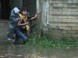 Una mujer cruza una calle inundada en Oaxaca. Se prevé que hoy 'Odile' se convierta en huracán. EFE  /
