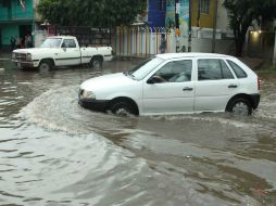 Un vehículo se abre paso por una calle inundada en Oaxaca. EFE /