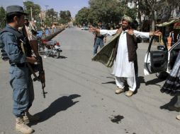 Miembros de las fuerzas de seguridad afganas registran a un hombre en una calle de Ghazni. EFE /  N. Haqjoo