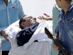 Médicos y militares egipcios acompañan a Hosni Mubarak, luego de escuchar que su veredicto es pospuesto hasta Noviembre. AP / H. Ammar