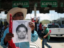 Un padre de familia muestra la foto de uno de los estudiantes desaparecidos. EFE / J. L. de la Cruz