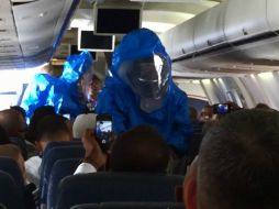 Médicos con trajes de seguridad suben al avión para extraer al pasajero. YOUTUBE / Patrick Narvaez