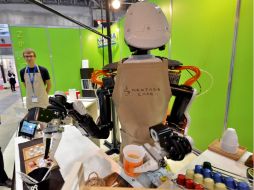 El Nextage usa sus 'manos' para servir café a los asistentes al evento. AFP / Y. Tsuno