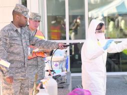Militares de la Base Aérea Eglin, Florida, rocían de cloro un traje de protección durante una capacitación contra el ébola. AP /