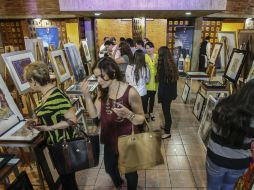 Los asistentes disfrutan de canapés, tequila y vino mientras observan las obras en venta. EL INFORMADOR / F. Atilano