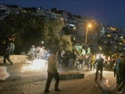 Manifestantes palestinos son dispersados por la policía antidisturbios con gas lacrimógeno y bombas de sonido. EFE / M. Abu Turk