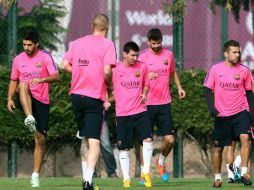 Luis Suárez (izq.) y Lionel Messi (centro) volverían a formar el ataque culé junto al brasileño Neymar. EFE / T. Albir