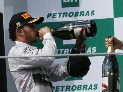Lewis Hamilton bebe champaña en el podio luego de terminar como segundo en el Campeonato Mundial de Fórmula Uno en Brasil. AP / S. Izquierdo