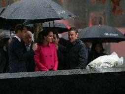 La pareja deposita un arreglo floral en uno de los dos espejos de agua ubicados donde solían estar las torres. AFP / S. Platt