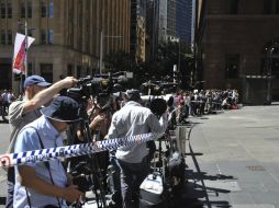 Medios de comunicación permanecen en las inmediaciones de la cafetería de Sídney. EFE / J. Carrett