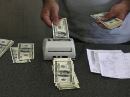 El tipo de cambio para solventar obligaciones en moneda extranjera pagaderas en el país es de 14.7853 pesos. AP / ARCHIVO