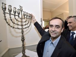 Las familias se reúnen para encender la primera de varias velas ceremoniales e intercambiar regalos. AFP / P. Guyot