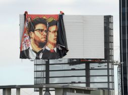 Trabajadores retiran un póster de la película en Hollywood, California. AFP / R. Beck