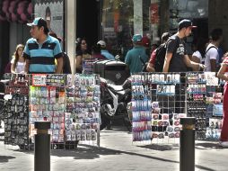 Bloqueo al peatón.  Vendedores de tecnología y accesorios para teléfonos cuelgan su mercancía en parrillas portátiles. EL INFORMADOR / E. Barrera