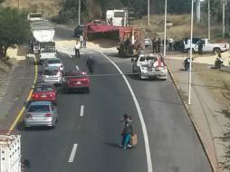 El maíz se regó por toda la carpeta asfáltica; con maquinaria, autoridades la retiran para reabrir la circulación. ESPECIAL / Bombertos de Tlajomulco